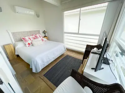 a bedroom with a bed and a desk with a television at Casa de Playa in Cartagena de Indias
