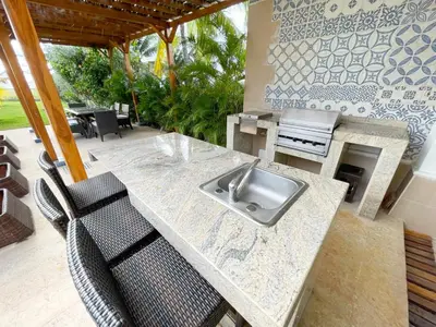 a kitchen with a counter with a sink and chairs at Casa de Playa in Cartagena de Indias