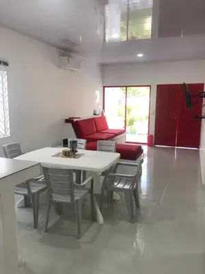a living room with a table and chairs and a couch at Bahia Tropical Sandia Kiwi Piña in Coveñas