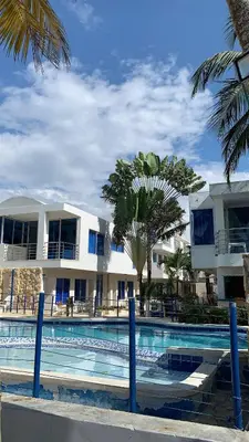 a resort with a swimming pool in front of a building at Hotel Portobello in Coveñas