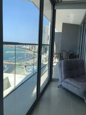 a living room with a chair and a large window at Apartamentos frente al mar en Morros City in Cartagena de Indias