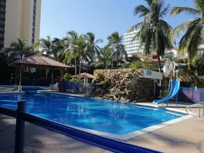 a swimming pool at a resort with palm trees at Casa, playa Bello Horizonte Santa Marta Colombia in Santa Marta