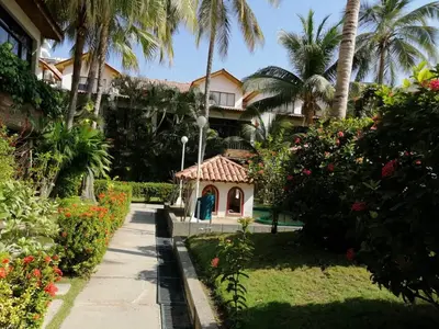 a garden in front of a building with palm trees at Casa, playa Bello Horizonte Santa Marta Colombia in Santa Marta