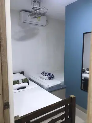 a small room with two beds and a mirror at Hostal Cartagena Sun in Cartagena de Indias