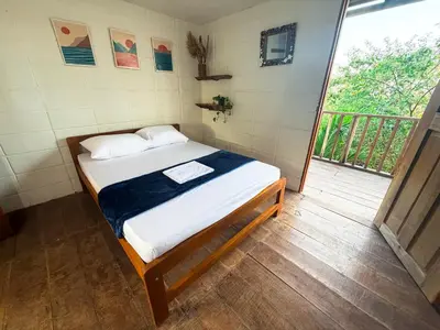 a bedroom with a bed in a room with a balcony at PALOMAR EcoCabaña in Santa Veronica