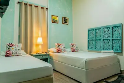 two beds in a room with blue walls at Casa Renacer in Cartagena de Indias