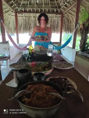 a woman sitting at a table with food on it at Los Versos de Zaira in San Onofre