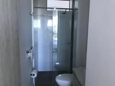 a bathroom with a glass shower with a toilet at Hermoso Apto con vista a la sierra y a Cabo Tortuga en el sector del Irotama en Santa Marta in Gaira