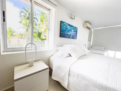 a white bedroom with a bed and a window at Quinta Del Mar El francés in Tolú