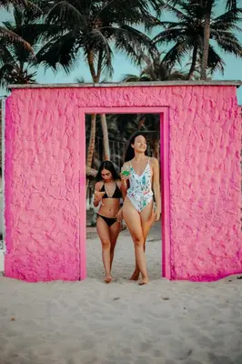 two women walking into a pink building on the beach at Marbelo Coveñas by Bernalo Hotels in Coveñas