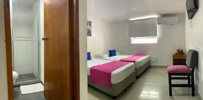 a small room with two beds and a stool at Hotel ITACO in Cartagena de Indias