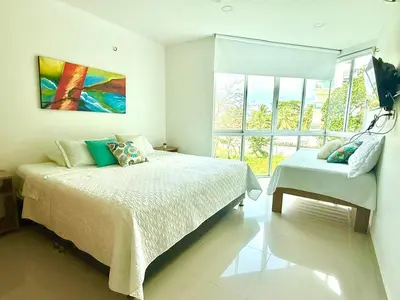 a bedroom with two beds and a large window at Magico Apartamento Frente al Mar 3 Habitaciones B21 in Coveñas