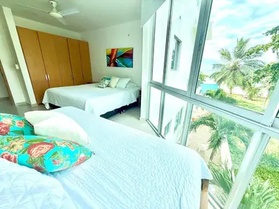 a bedroom with two beds and a large window at Magico Apartamento Frente al Mar 3 Habitaciones B21 in Coveñas