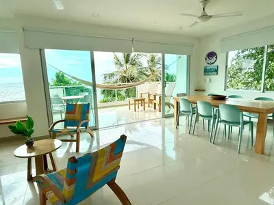a living room with a table and chairs and the ocean at Magico Apartamento Frente al Mar 3 Habitaciones B21 in Coveñas