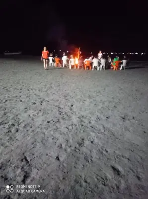 a group of people on the beach at night at HOSTAL BELLEZA TROPICAL in Moñitos