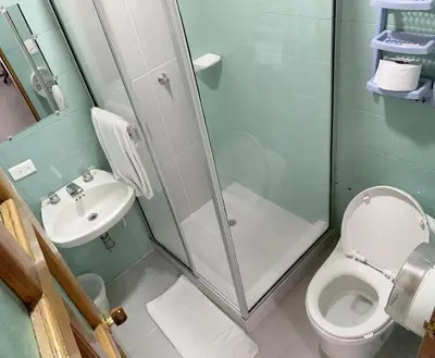 a bathroom with a shower and a toilet and a sink at Hotel Corozal Plaza in Corozal