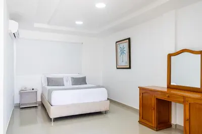 a bedroom with a bed and a mirror and a dresser at Hotel Corozal Plaza in Corozal