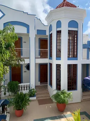 a blue and white house with plants in front of it at Hotel Corozal Plaza in Corozal
