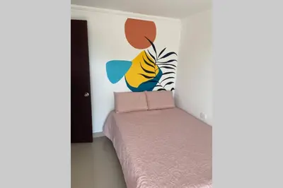 a bedroom with a bed with a painting on the wall at Apto en Getsemani el barrio mas cool de Cartagena in Cartagena de Indias
