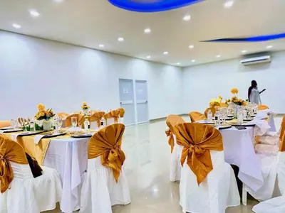 a banquet hall with white tables and chairs with bows at Playa Norte Hotel in Cartagena de Indias