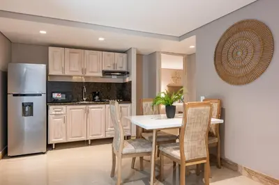 a kitchen with a table and chairs and a refrigerator at Apartamentos casa Gimani in Cartagena de Indias