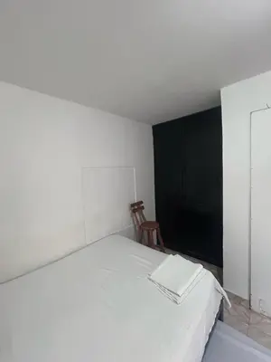 a bedroom with a white bed and a chair at Sophia House in Cartagena de Indias