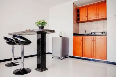 a kitchen with a counter with stools and a refrigerator at Apartamento Lorenita in Cartagena de Indias