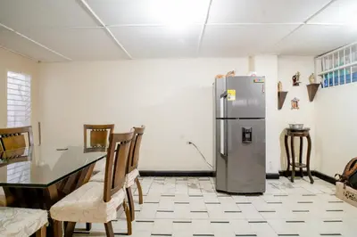 a kitchen with a refrigerator and a table and chairs at HABITACION PRIVADA EN CASA DE MIS PADRES in Barranquilla