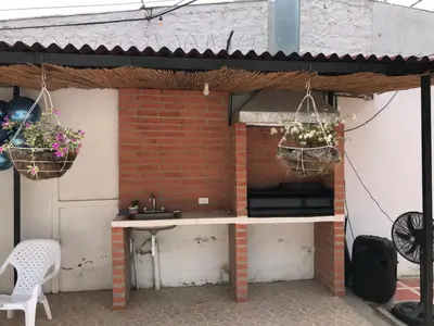 a patio with two flower baskets hanging from a brick wall at CABAÑA LAS MARIAS, Climatizada, Piscina y BBQ in Santa Marta