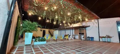 a patio with chairs and a table and lights at CABAÑA LAS MARIAS, Climatizada, Piscina y BBQ in Santa Marta