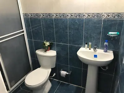 a bathroom with a toilet and a sink at CABAÑA LAS MARIAS, Climatizada, Piscina y BBQ in Santa Marta
