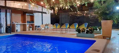 a swimming pool with chairs and a table and a table and a table at CABAÑA LAS MARIAS, Climatizada, Piscina y BBQ in Santa Marta