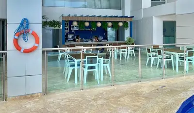 a restaurant with white chairs and tables and a clock at Apartamento con vista al mar piso 19 Bocagrande in Cartagena de Indias