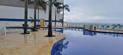 a swimming pool with palm trees and the ocean at Apartamento con vista al mar piso 19 Bocagrande in Cartagena de Indias