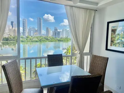 a balcony with a table and chairs and a large window at Cristoforo Oasis in Cartagena de Indias