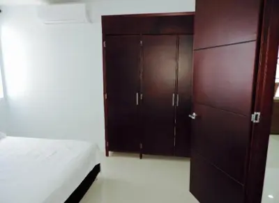 a bedroom with a bed and a wooden cabinet at Cristoforo Oasis in Cartagena de Indias