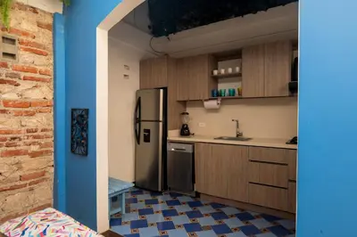 a kitchen with a stainless steel refrigerator and wooden cabinets at Casa Familiar - Maria de las Palmas -Getsemani in Cartagena de Indias