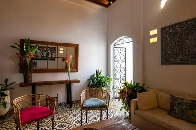 a living room with a couch and chairs and a window at Casa Familiar - Maria de las Palmas -Getsemani in Cartagena de Indias