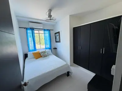 a small bedroom with a bed and a window at Cabana Costa Azul in Coveñas