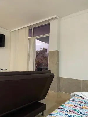 a bedroom with a bed and a large window at Apartaestudio amplio in Barranquilla