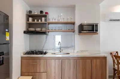 a kitchen with a sink and a microwave at Apartamento en Bocagrande - Piscina, Jacuzzi y Mar in Cartagena de Indias
