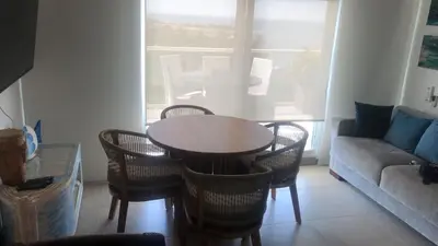a living room with a table and chairs and a couch at Loft de Lujo - Wifi, piscina y mar in Santa Marta