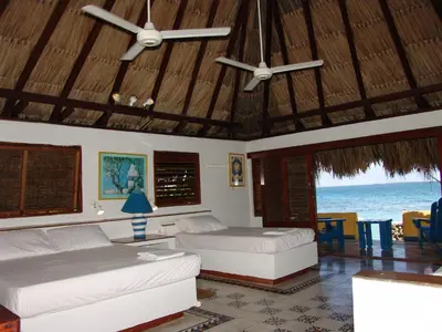 a bedroom with two beds and a view of the ocean at Hotel Isla Del Pirata in Isla del Pirata