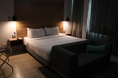 a bedroom with a large bed and a chair at The Blue Hotel in Cartagena de Indias