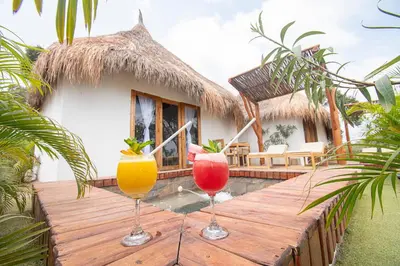 two glasses of cocktails sitting on a wooden deck at AMALIFE Beach Club & Hotel in Tierra Bomba