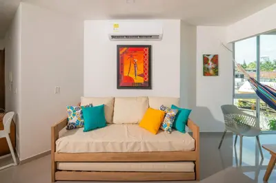 a living room with a couch with colorful pillows at Magico Apartamento Frente al Mar 2 Habitaciones B22B in Coveñitas