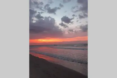 a sunset on the beach with the ocean at APARTA-SUITES EN CARTAGENA JUNTO a LA PLAYA in Cartagena de Indias