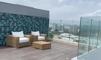 a balcony with two wicker chairs and a glass wall at Spiaggia di Cartagena primera línea de playa in Cartagena de Indias