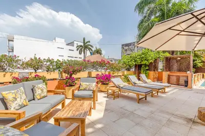 a patio with chairs and tables and an umbrella at Casa Morales Getsemaní in Cartagena de Indias