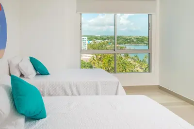 two beds in a room with a large window at Magico Apartamento Frente al Mar 3 Habitaciones AR91 in Pativilca